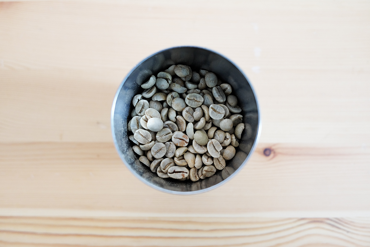 カップに入った100gのコーヒー生豆