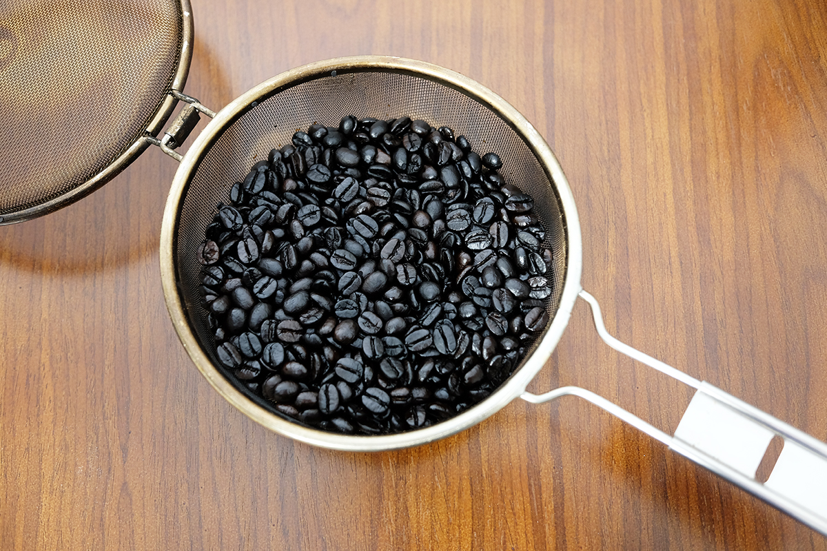 手網に入った深煎りのコーヒー豆