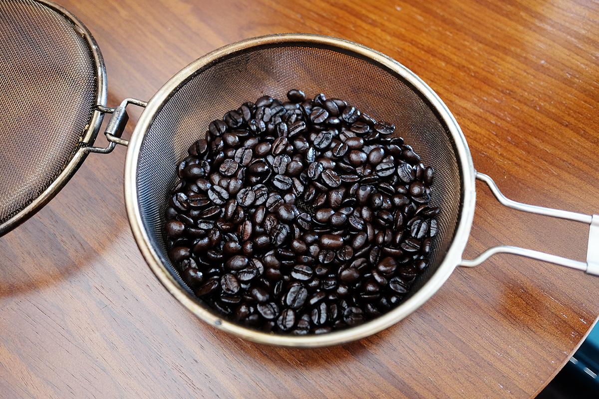 手網に入った焙煎したコーヒー豆